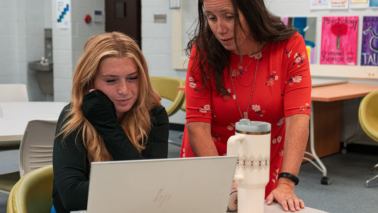 instructor helping a student who is looking at her laptop
