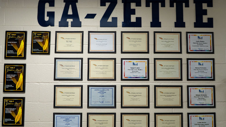 Award plaques and certificates hung on a wall