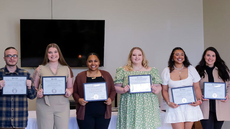 smiling students holding certificates