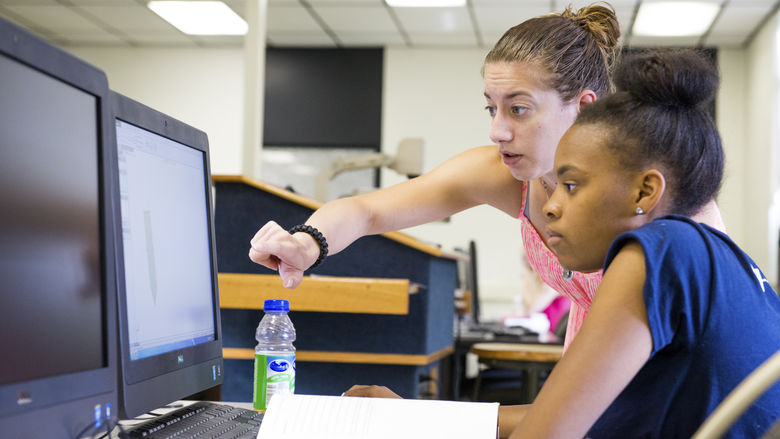 teacher with student at computer