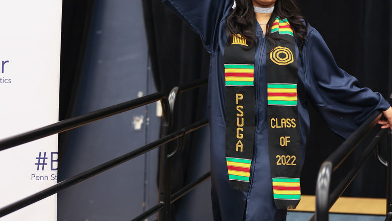Psychology (B.S.) Degree Candidate Sueriah Om’Unique Timsah waves her diploma in the air