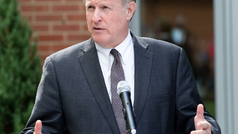 man standing at podium talking into microphone