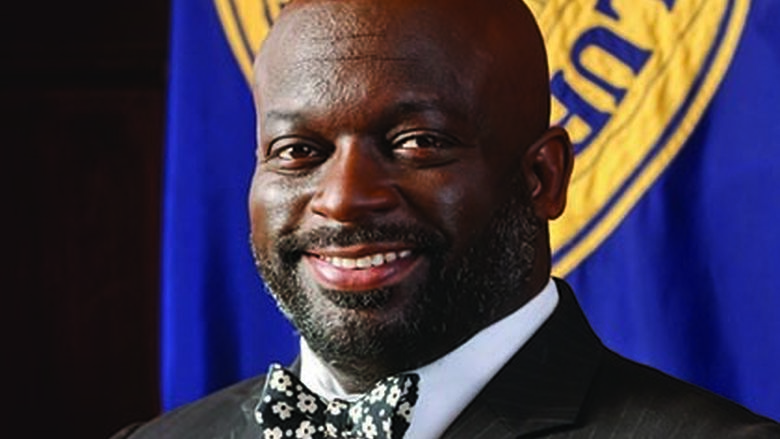 Profile photo of man smiling wearing a tuxedo. 