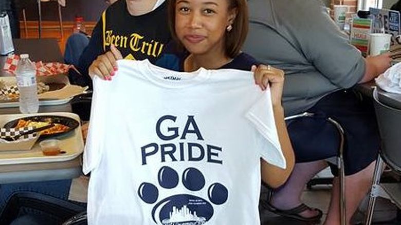 students holding t-shirt