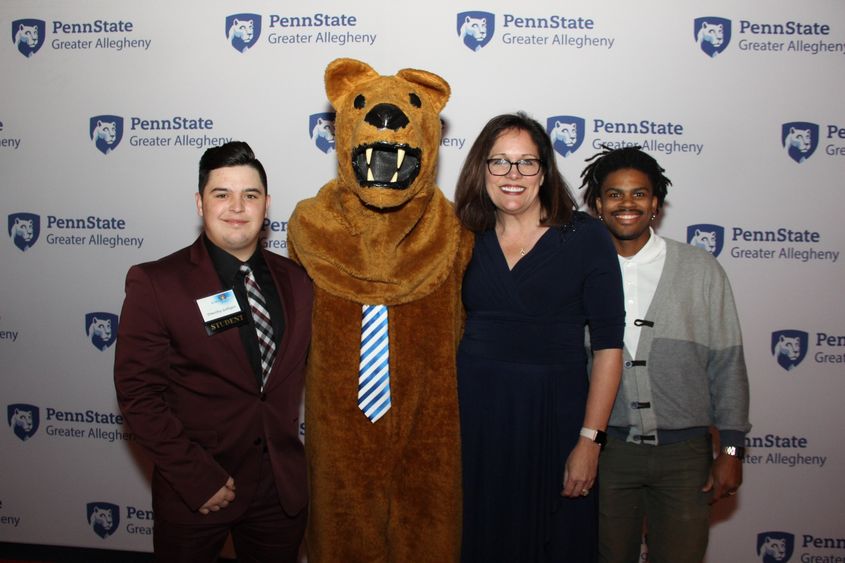 Lion mascot with students and Greater Allegheny chancellor 