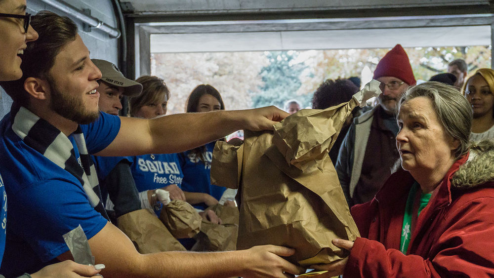 Students bag a thanksgiving meal for a community member.