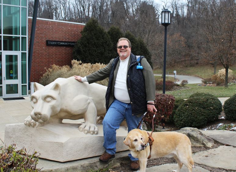 Jerry Pastories and Service Dog Nittany standing in front of the lion shrine