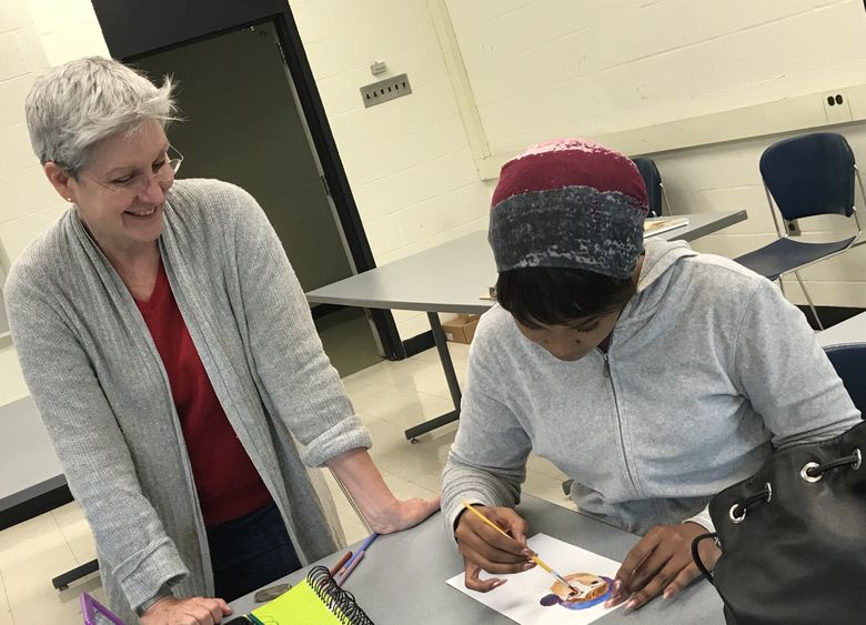 Teacher looking at student work on document