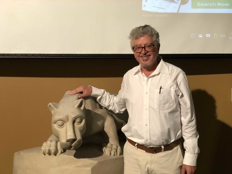 Dr. Winter standing next to a smaller scale version of the Lion Shrine. 