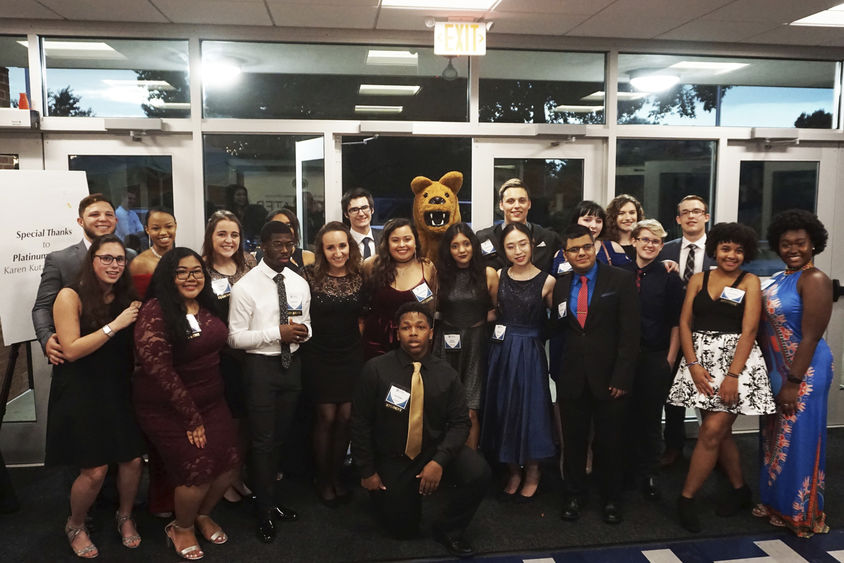 Greater Allegheny Students standing next to mascot in front of doorway