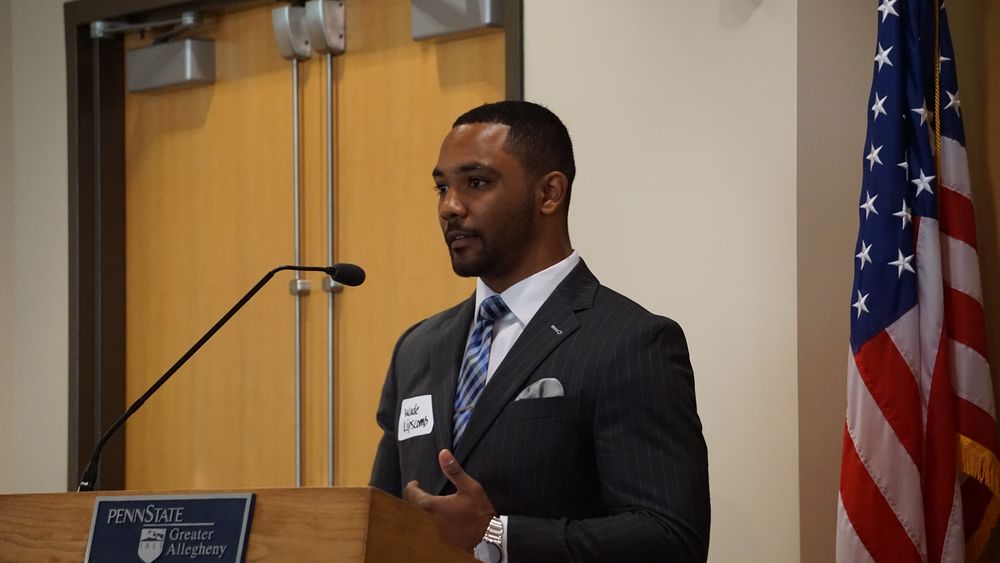 Man standing at podium talking into a microphone