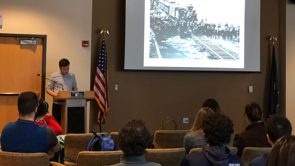 Presenter discussing current slide of old Pittsburgh to students