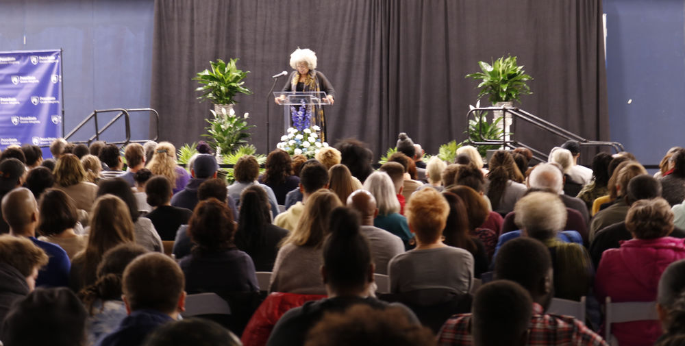 Dr. Angela Davis standing on stage preparing to talk to a crowd of people. 