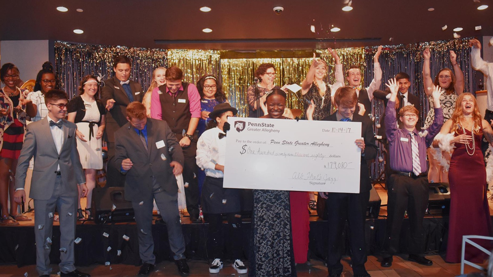 Students reveal donation total at this year’s All That’s Jazz scholarship benefit on October 14th.
