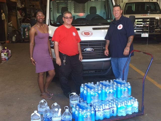 students load cases of water on to truck