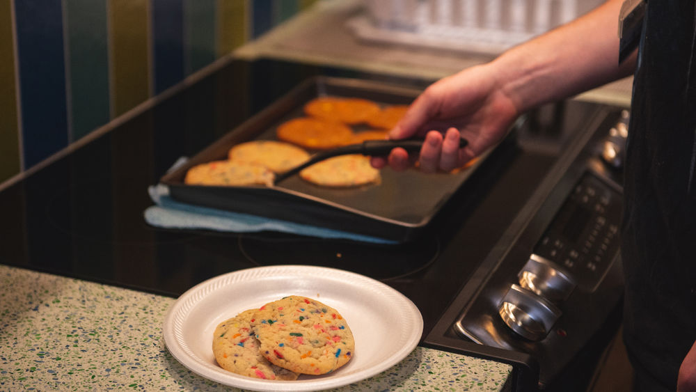 Student removing cookies from a baking sheet
