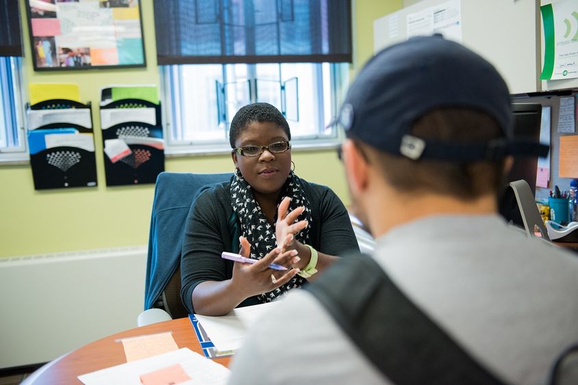 woman at desk with male student