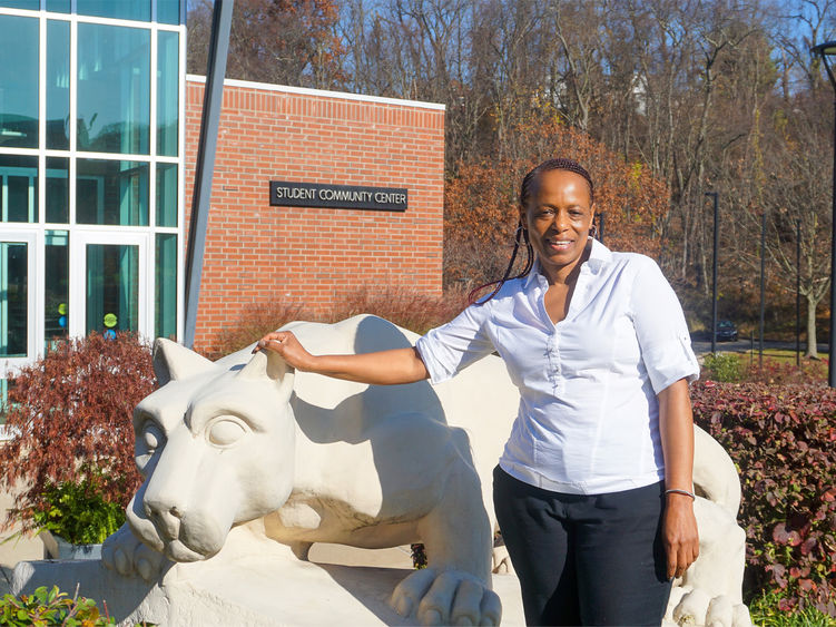 Woman standing by Greater Allegheny Lion Shrine