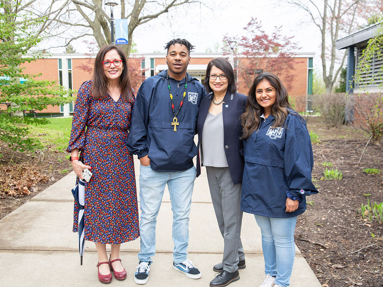 Four people standing outside smiling